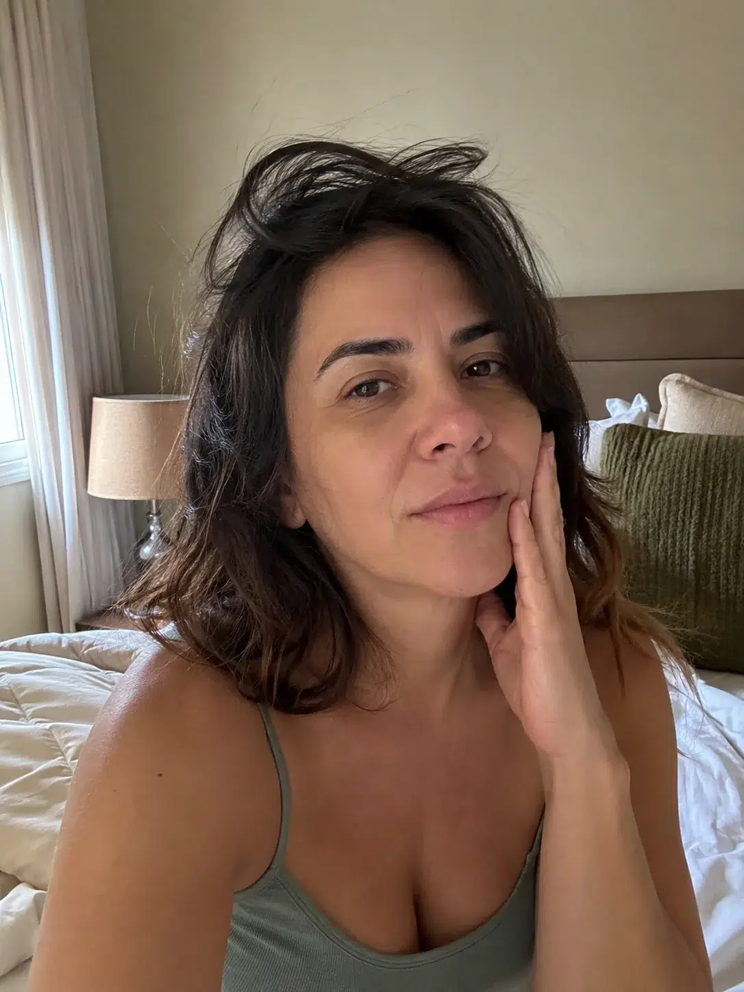 Mulher com dor na mandíbula ao acordar, sinal comum de disfunção da ATM (DTM)